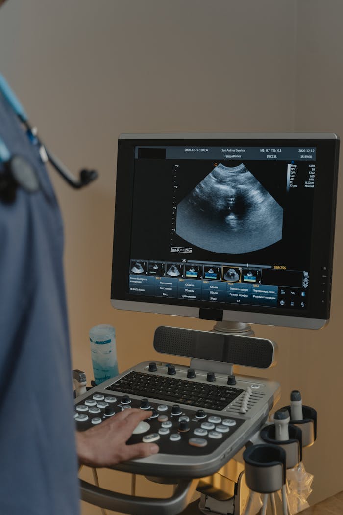 A healthcare professional using an ultrasound machine in a clinical setting.