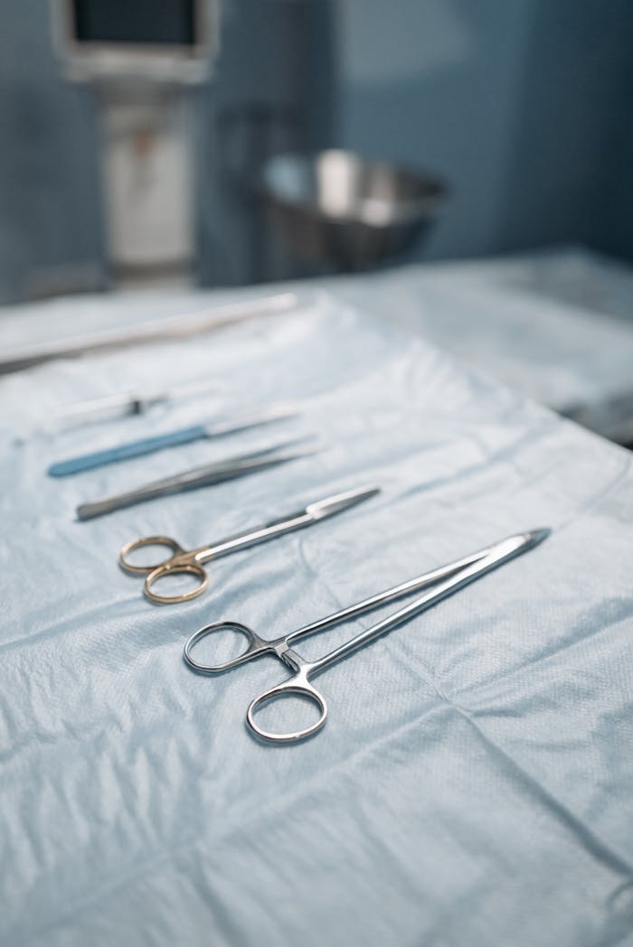 Close-up of surgical tools on a sterile drape in an operating room.